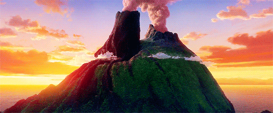 L'iconica isola vulcanica dal cortometraggio Pixar "Lava", che mostra i due volti dei vulcani ("lui" e "lei") uniti, mentre eruttano vapore e fumo in un cielo infuocato all'ora d'oro.