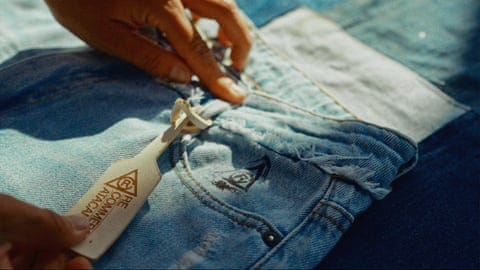 A sales tag is attached to a pair of jeans