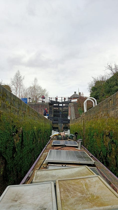 Three images, the first is just the end of a pink narrow boat in front of the canal water, with a canal path also in view. Second image is of the top of a narrow boat with solar panels, it is inside a lock, with the lock edges clearly visible including brick walls and trees above. Thirdly there is a picture of a sunset over the canal with the reflection in the still water.
