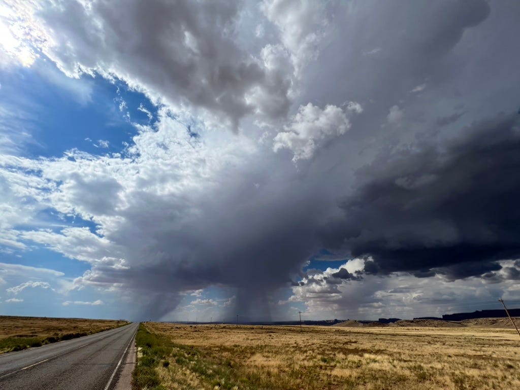 A road with a large cloud in the sky

Description automatically generated
