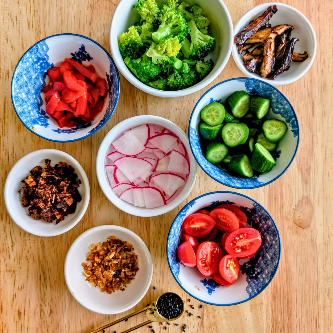 Overhead view of a wooden cutting board with small bowls of prepped ingredients for broccoli and shiitake mushroom salad, including chopped broccoli, sliced mushrooms, dressing, and seasonings.