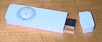 an original ipod shuffle.  a white USB stick with circular music controls and cap
