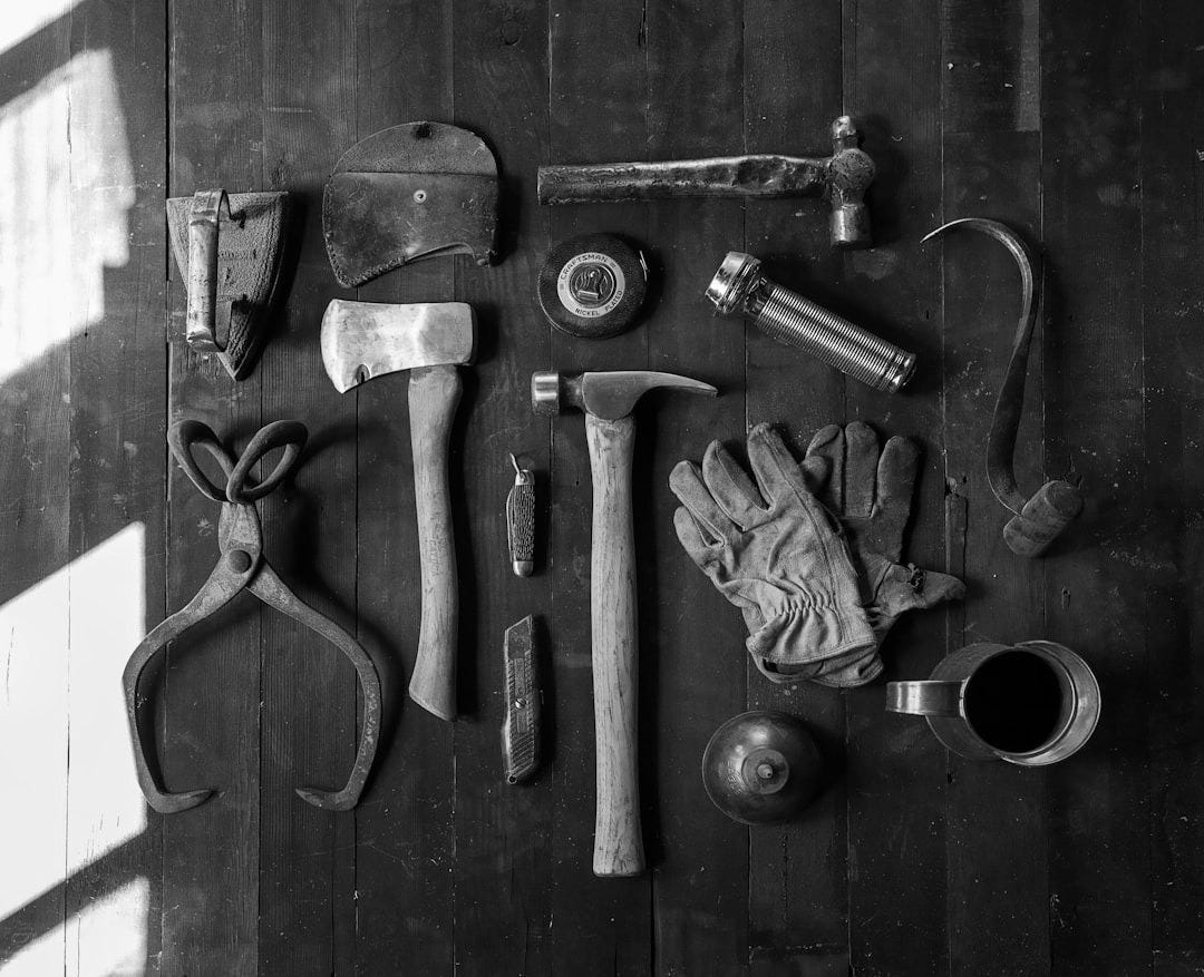 clothes iron, hammer, axe, flashlight and pitcher on brown wooden table clothes iron, hammer, axe, flashlight and pitcher on brown wooden table