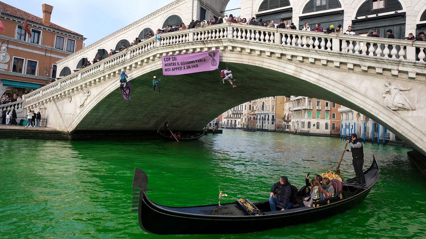 People ride in boats as waters of Grand Canal turned green after a protest by 'Extinction Rebellion' climate activists in Venice, Italy, December 9, 2023. REUTERS/Manuel Silvestri TPX IMAGES OF THE DAY People ride in boats as waters of Grand Canal turned green after a protest by 'Extinction Rebellion' climate activists in Venice, Italy, December 9, 2023. REUTERS/Manuel Silvestri TPX IMAGES OF THE DAY