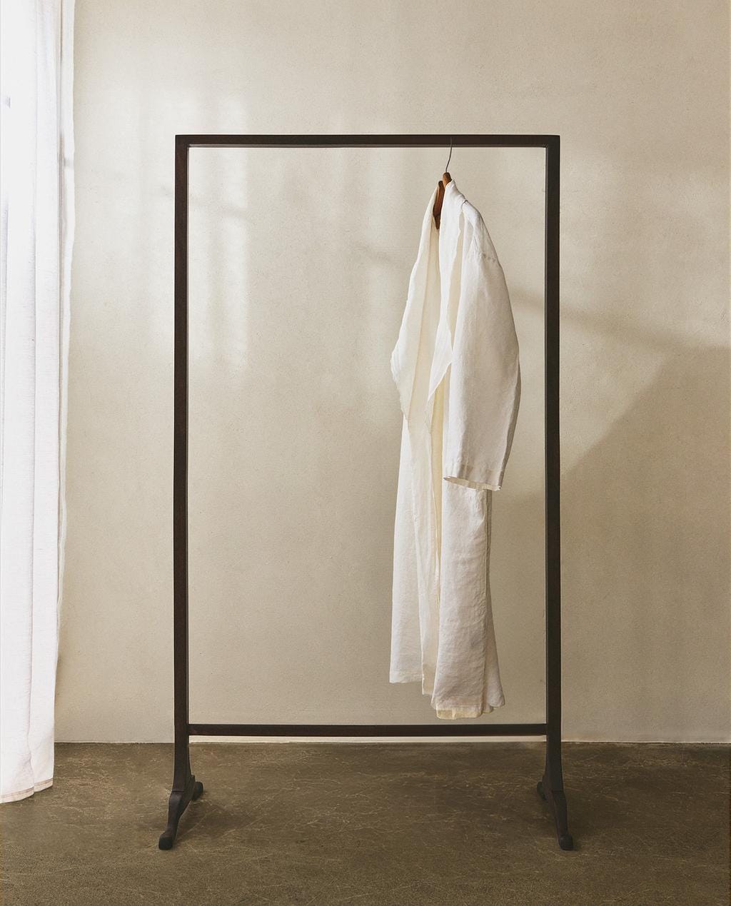 wooden clothes rack with one single item hanging
