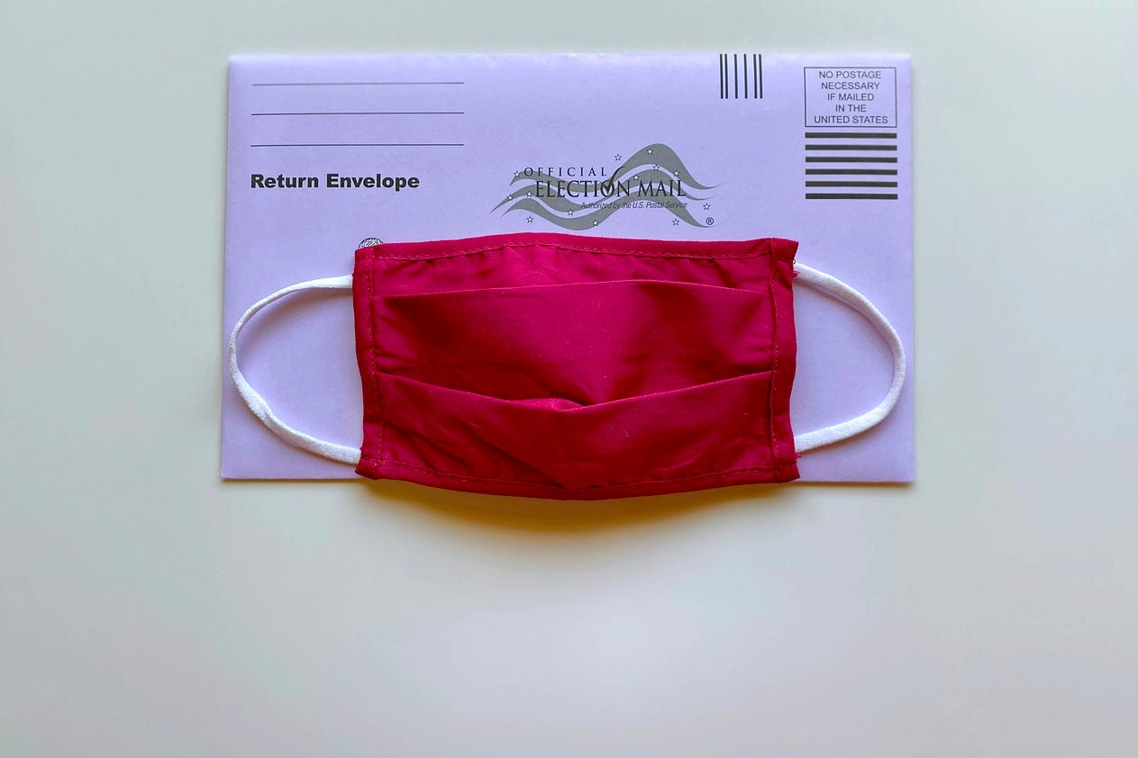 Covid-19 mask sitting atop a mail-in ballot Covid-19 mask sitting atop a mail-in ballot