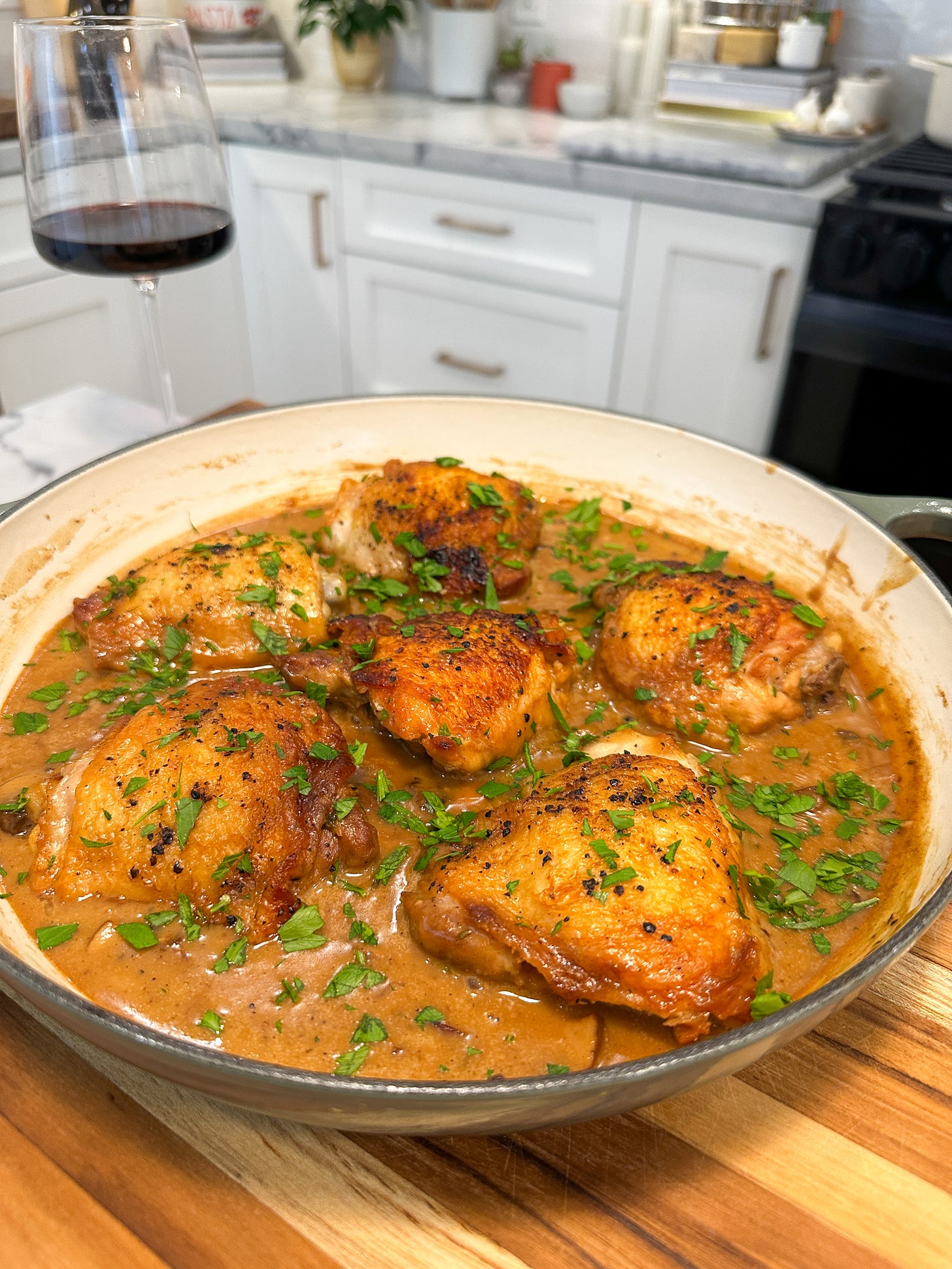 Chicken fricassee served in a creamy white wine sauce with mushrooms, butter and herbs in a skillet