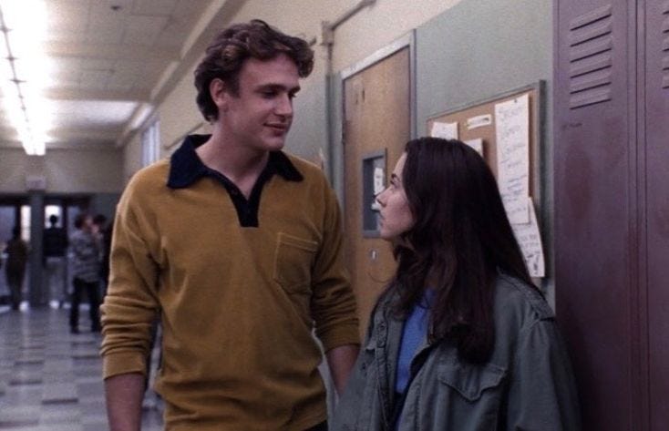 This may contain: a man and woman standing next to each other near lockers in an office building