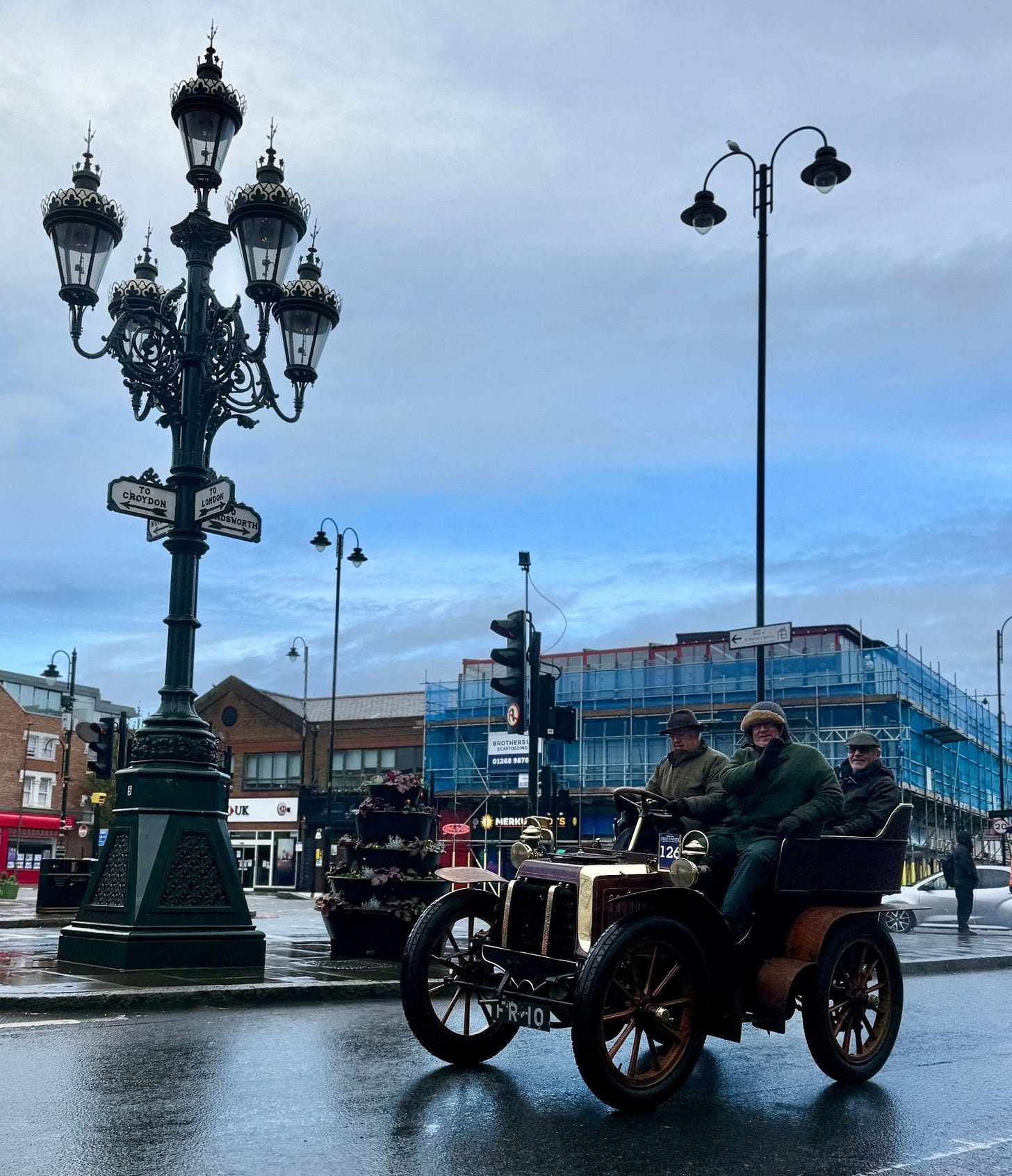 May be an image of car, street and text