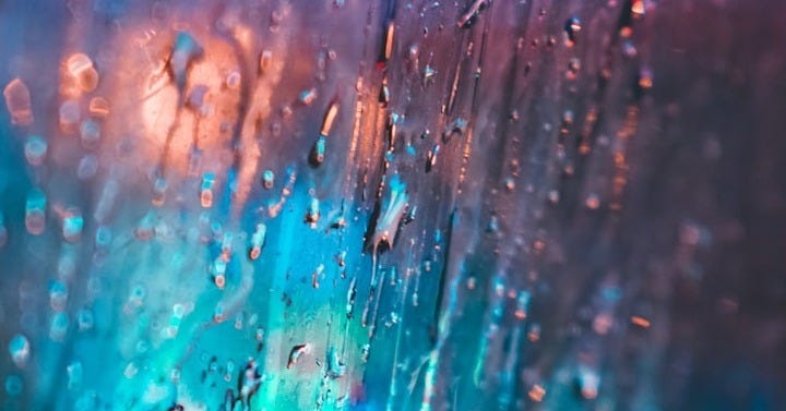 a close up of a window with rain drops a close up of a window with rain drops