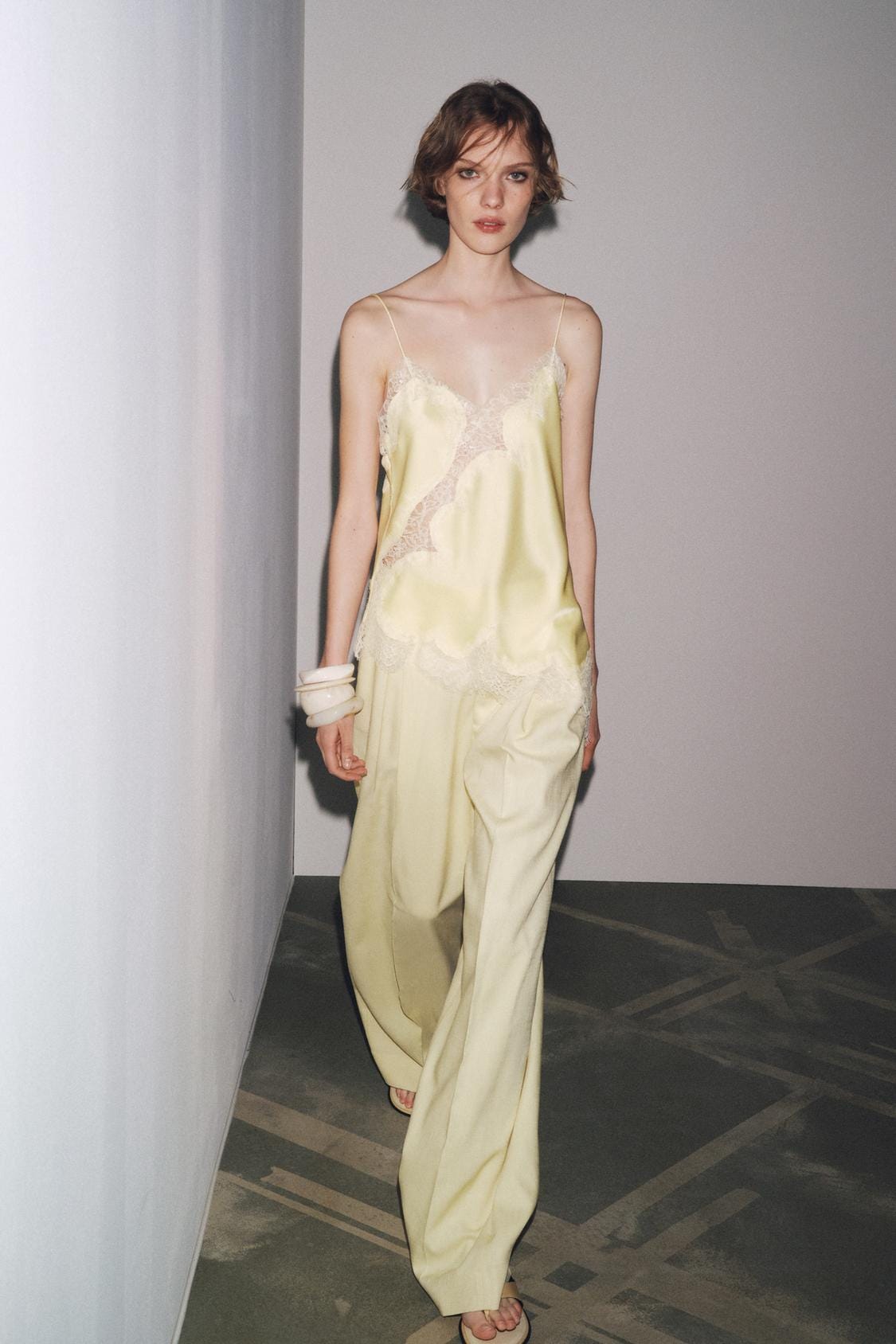 Yellow cami top set featuring a V-neck, spaghetti straps and matching lace trim, paired with wide-leg yellow trousers.