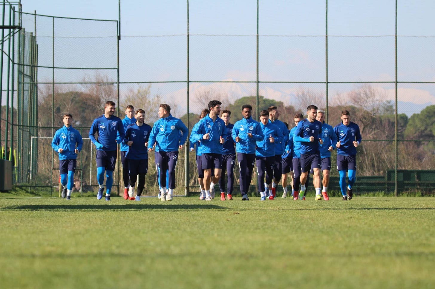 Photo of Floridsdorfer Athletiksport-Club players jogging around a training pitch Photo of Floridsdorfer Athletiksport-Club players jogging around a training pitch