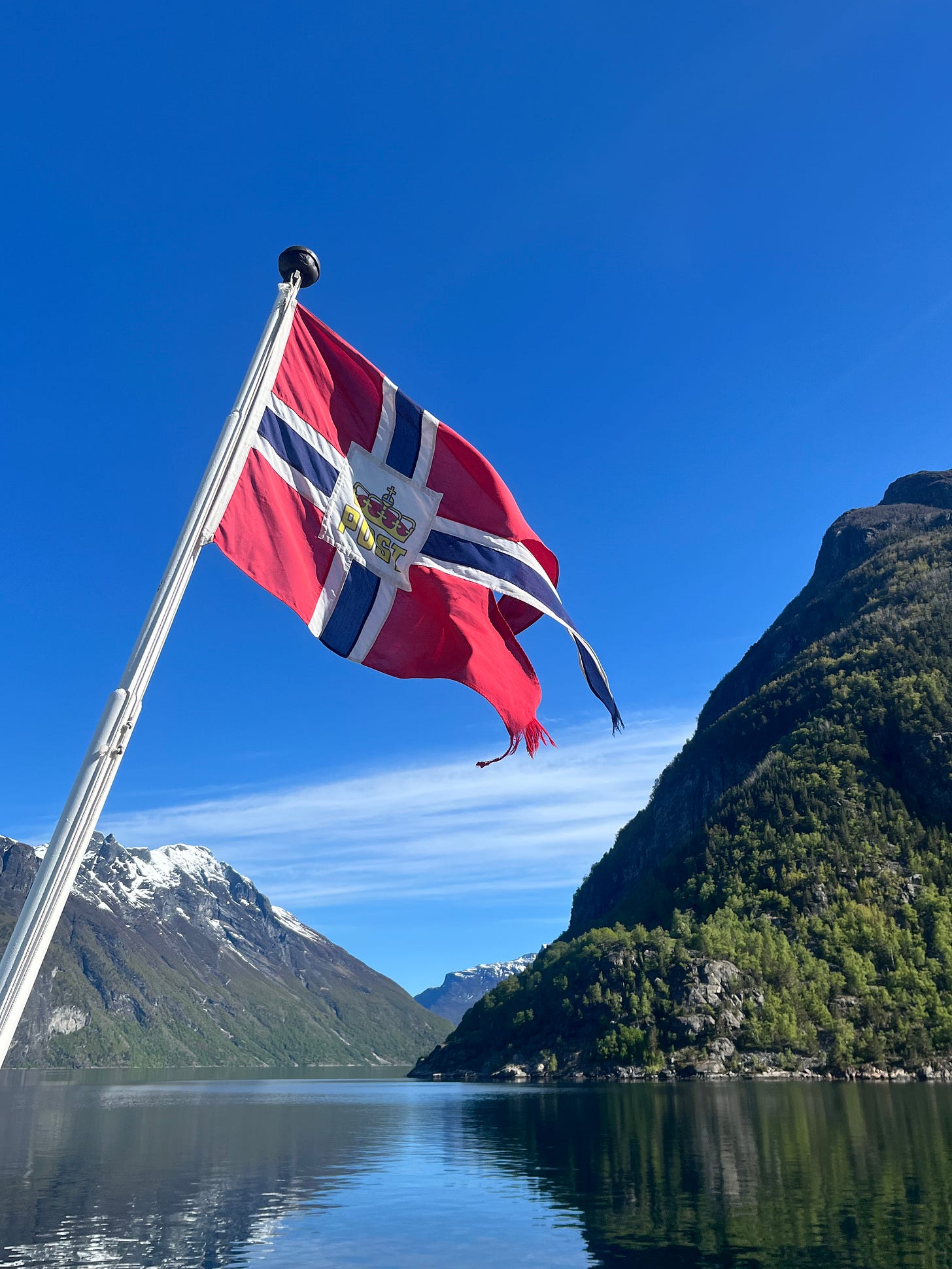 a Flag takes precedence over a lakeside view with mountains looming in the background
