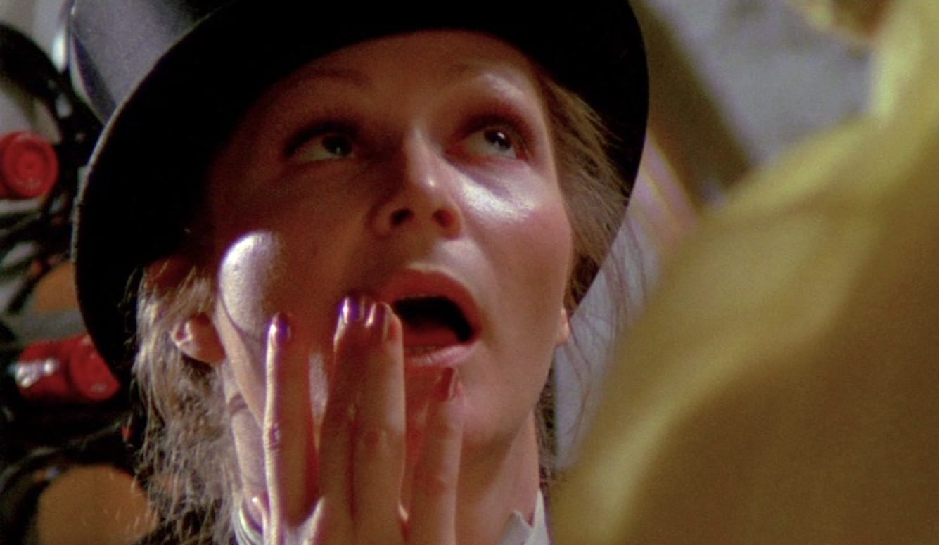 A close-up still from the movie Naked Came the Stranger, focusing on the lead actress’s face. She looks up, mouth open. A close-up still from the movie Naked Came the Stranger, focusing on the lead actress’s face. She looks up, mouth open.
