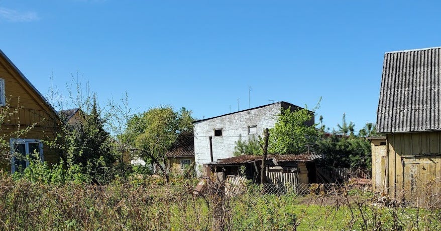 Three small, ramshackle homes against a bright blue sky