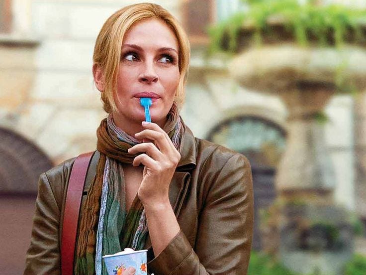 This may contain: a woman holding a blue toothbrush in her mouth with the words eat pray love on it