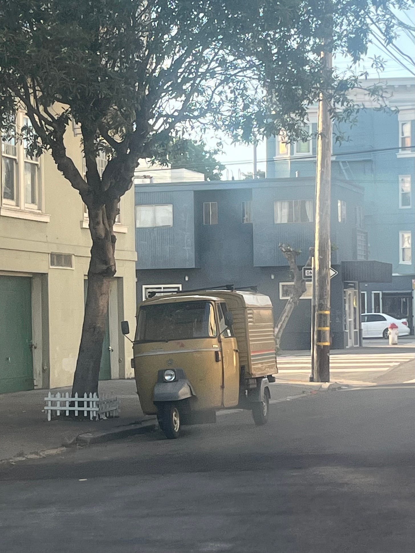 A yellow rickshaw parked along a side street in the Richmond