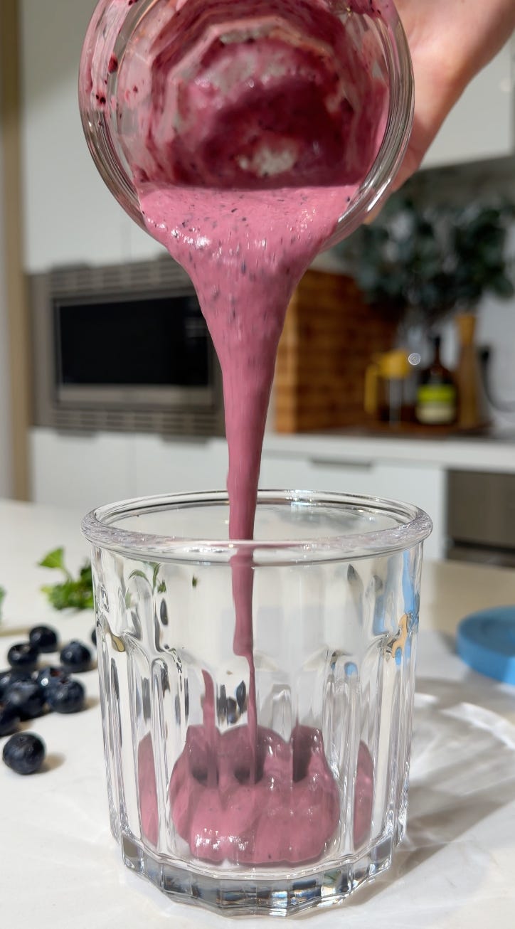 Blueberry basil salad dressing being poured into a glass jar