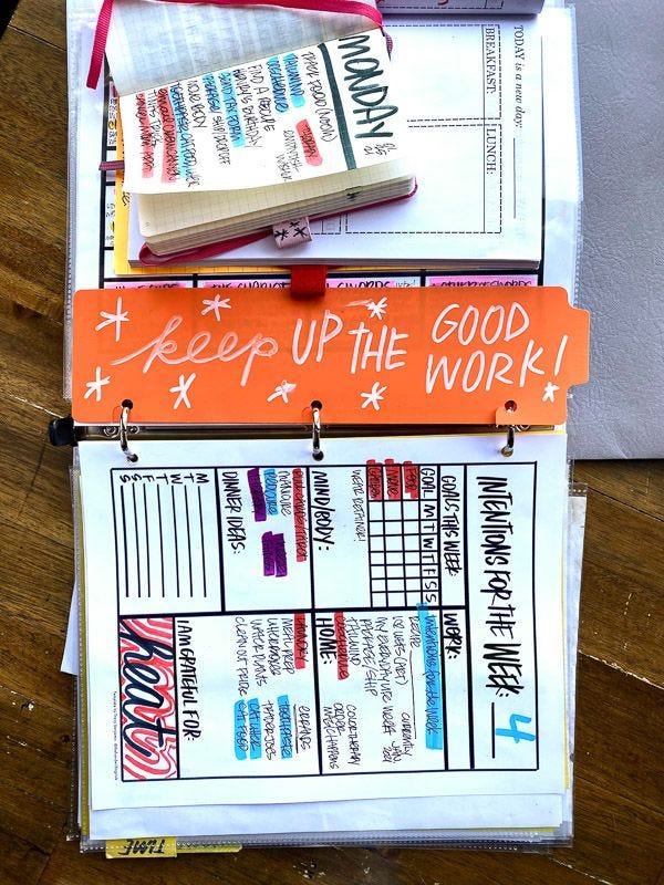 This may contain: an open binder that has some books on top of it with writing on the pages