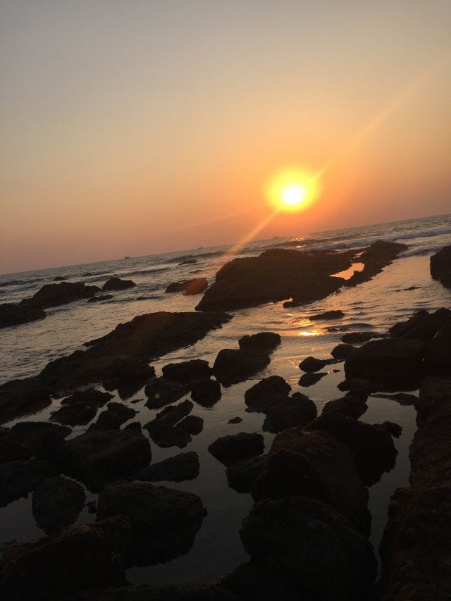 A sun set on the oceans with rocks peppered all over the horizon. A sun set on the oceans with rocks peppered all over the horizon.