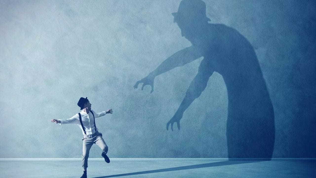 man looking scared of his shadow on wall