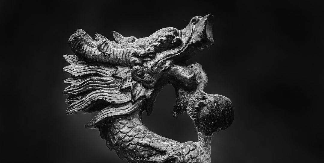 a black and white photo of a dragon statue a black and white photo of a dragon statue