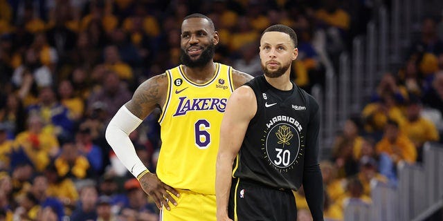 LeBron James stands next to Steph Curry