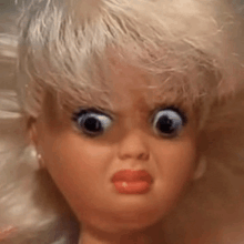 a close up of a doll 's face with big eyes .