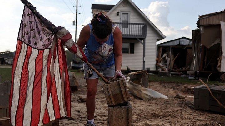 Left: Roxanne Brooks mounts an American flag to a stack of cinderblocks outside her friend's destroyed mobile home (R) in the aftermath of Hurricane Helene flooding on October 6, 2024 in Swannanoa, North Carolina. Rescue and recovery efforts continue as the death toll has risen to over 230 in what is now the deadliest US mainland hurricane since Katrina. Mario Tama/Getty Images. Right: A makeshift cardboard sign leans up against campaign posters near a relief center on Oct. 3, 2024, in Vilas, N.C. in the aftermath of hurricane Helene. Chris Carlson/AP Photo.