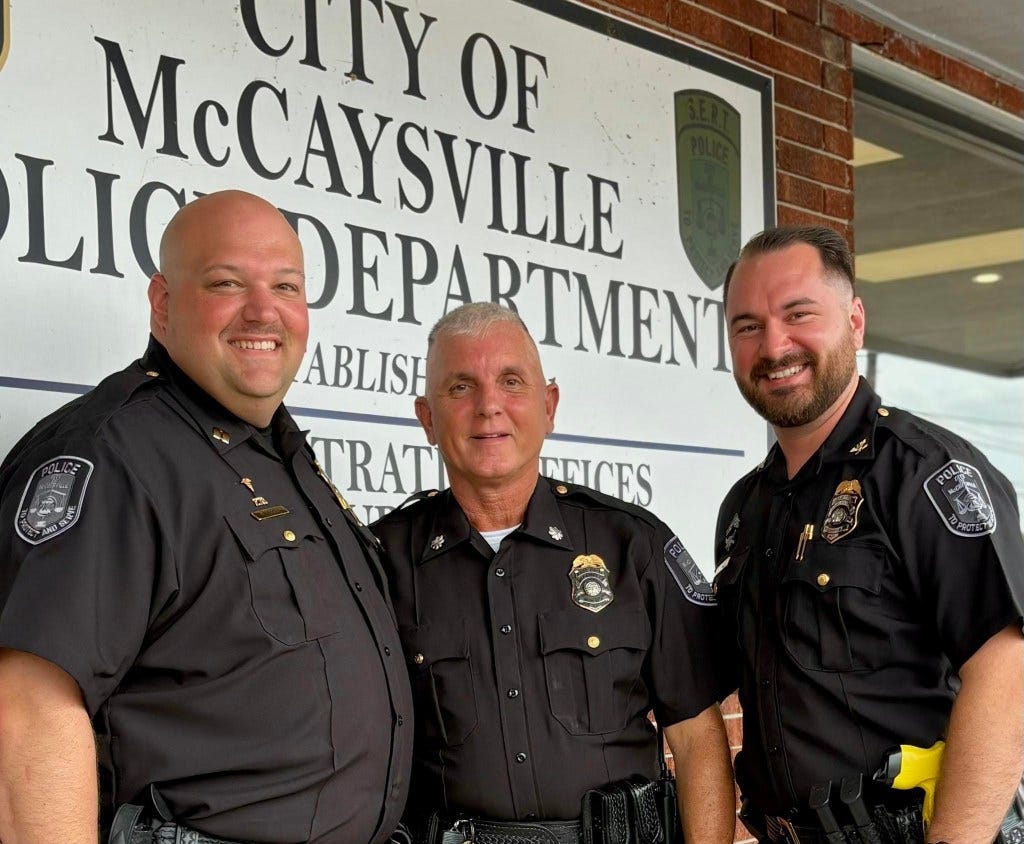 Three McCaysville police officers posing for a photo in front of the police department. Three McCaysville police officers posing for a photo in front of the police department.