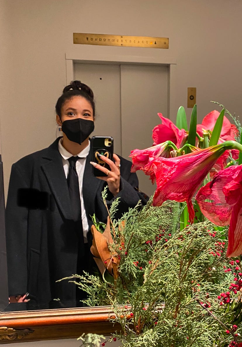 Kiana's first day on the job as a doorman wearing an oversized coat