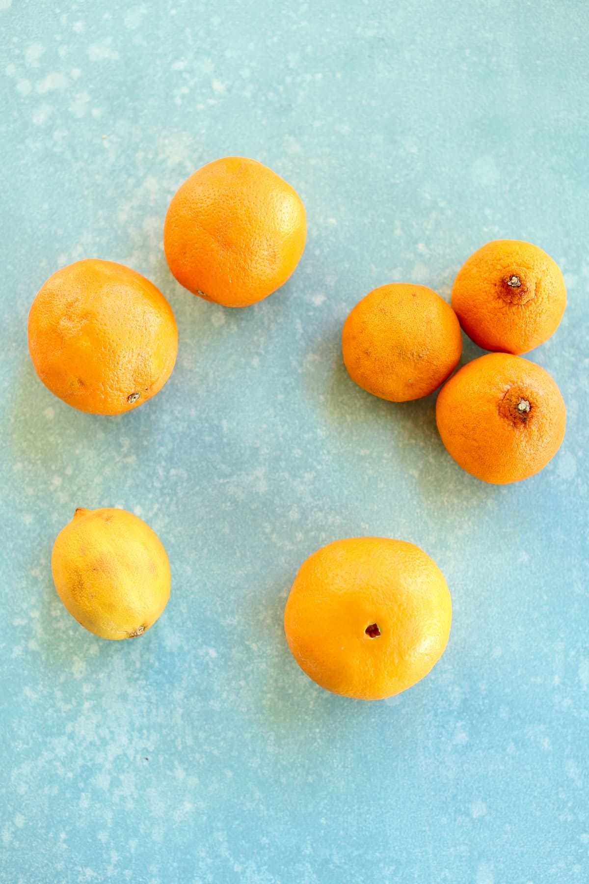 a scattering of citrus fruits on a blue table.