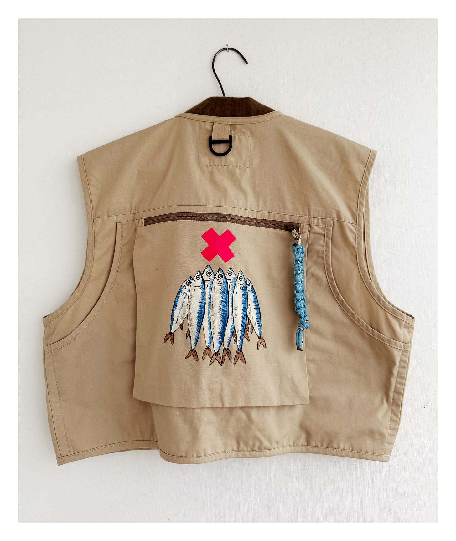 back view of fishing vest, with hand-painted fish and woven toggles.