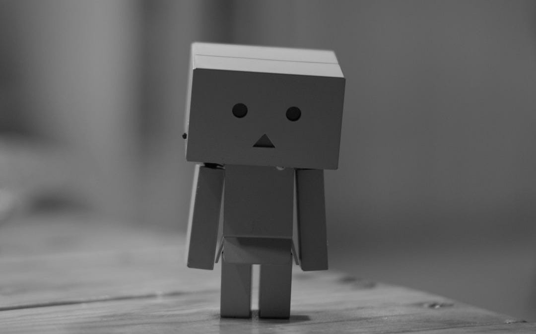 grayscale photo of box robot on table