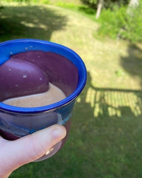 mug of bone broth hot cocoa next to a green lawn
