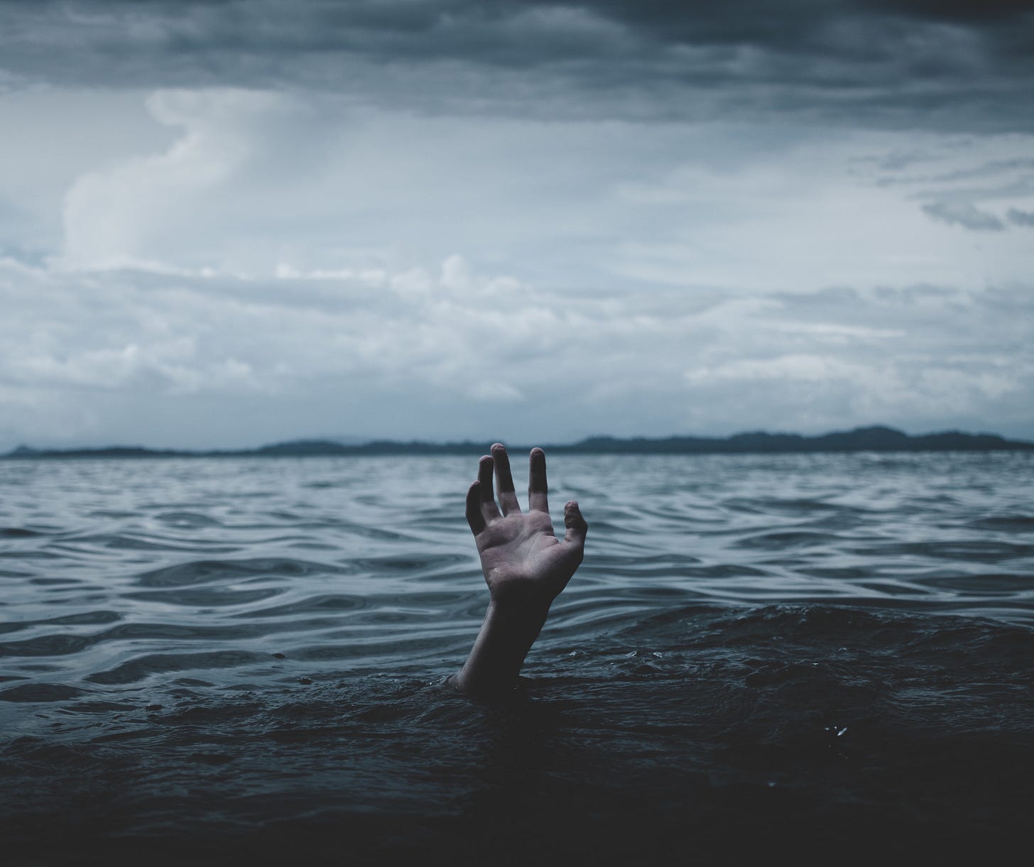 Image of a hand in the ocean as though someone is drowning Image of a hand in the ocean as though someone is drowning