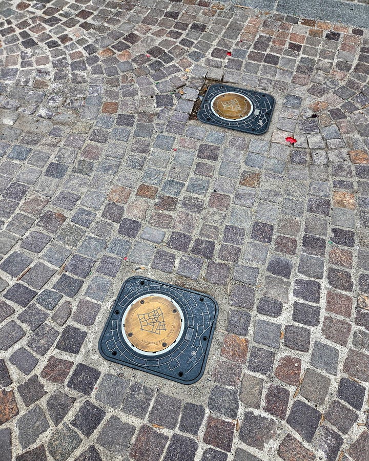 pavement with the metal signs with engraved drawings of the neighborhood and bicycle