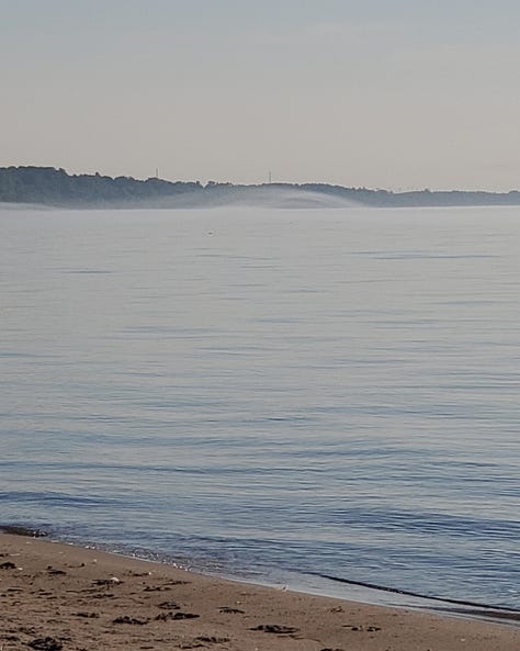 Three photos showing the lake showcasing mist, rock and sand.