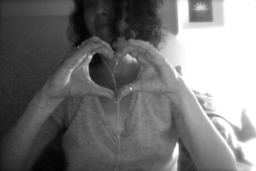 black and white photo of woman holding hands in shape of heart in front of her black and white photo of woman holding hands in shape of heart in front of her