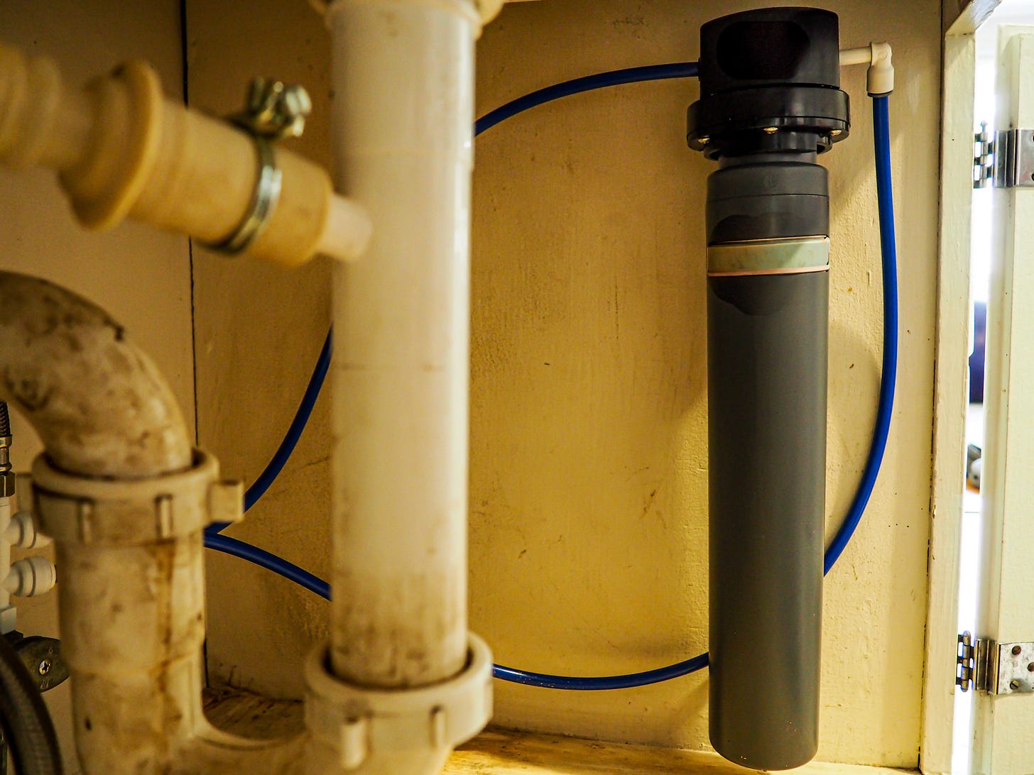 A filter installed underneath a kitchen sink. A filter installed underneath a kitchen sink.