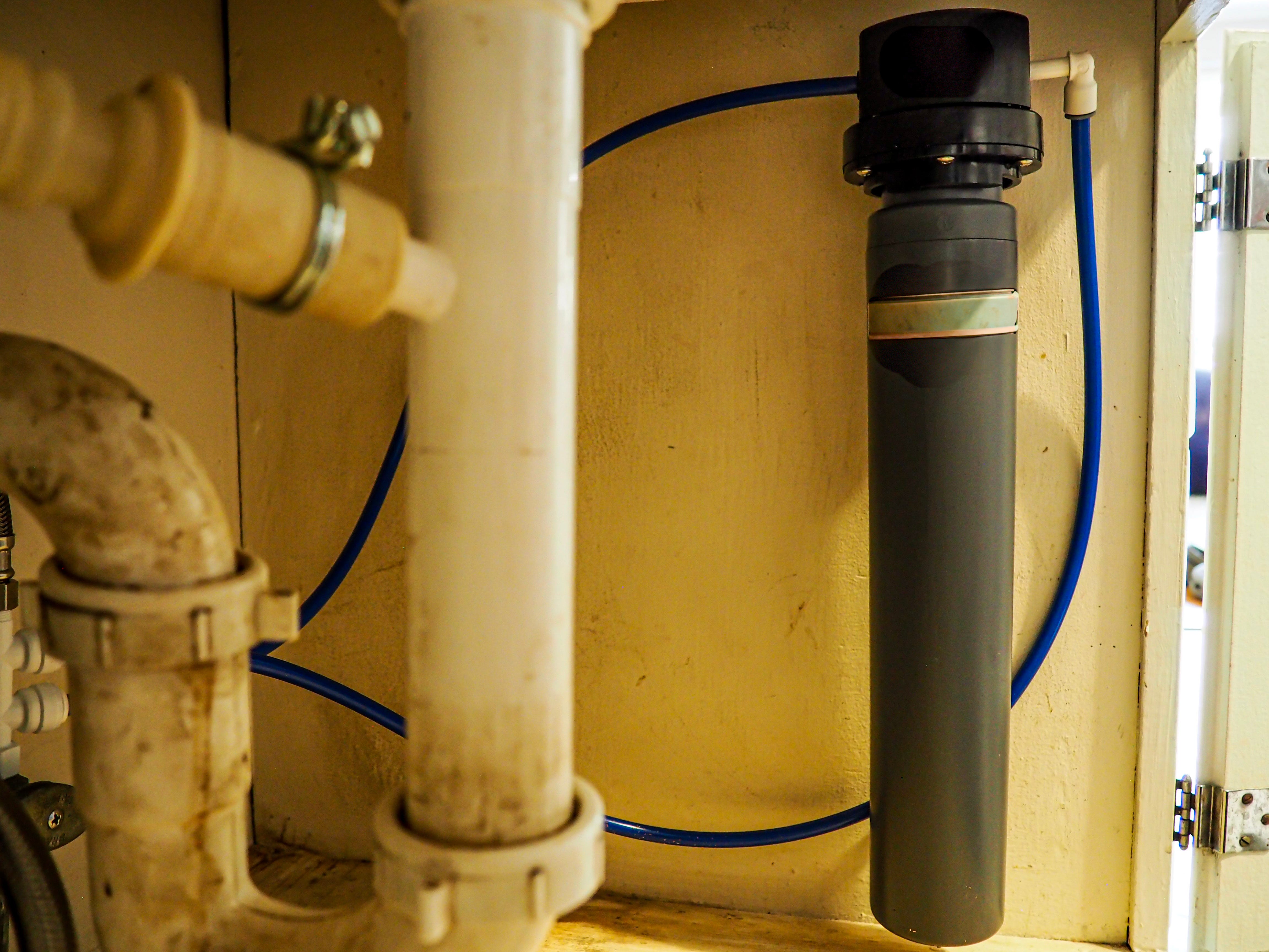 A filter installed underneath a kitchen sink.