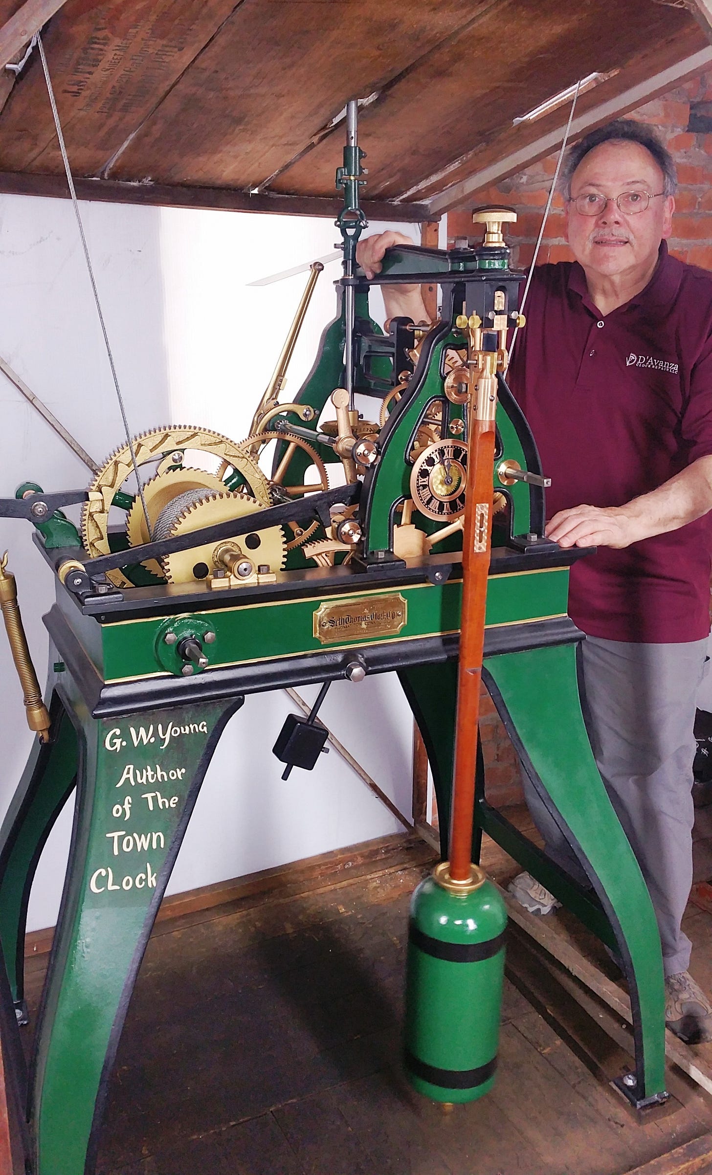 Man standing next to newly refurbished tower clock movement.