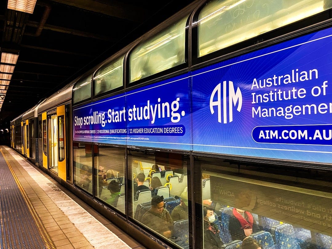 A train station with a sign for the australian institution of management