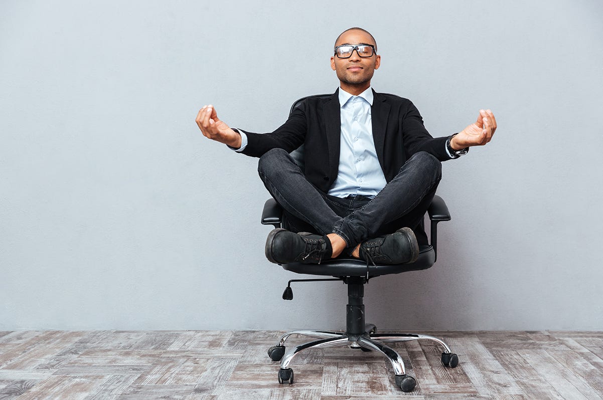 A person in a suit sitting on a chair

Description automatically generated with low confidence