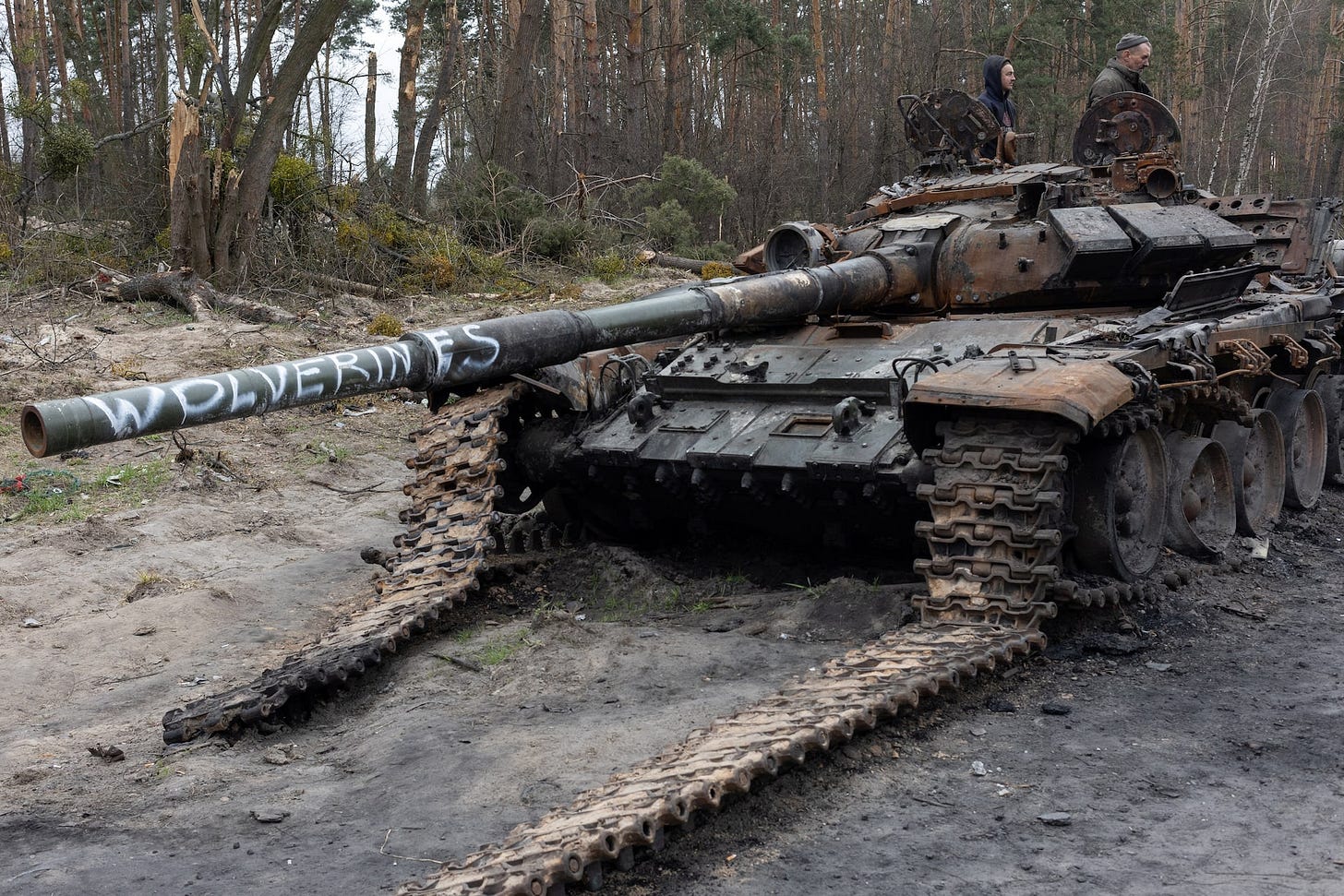 Scavengers search for useful metal parts in a destroyed Russian tank outside Kyiv