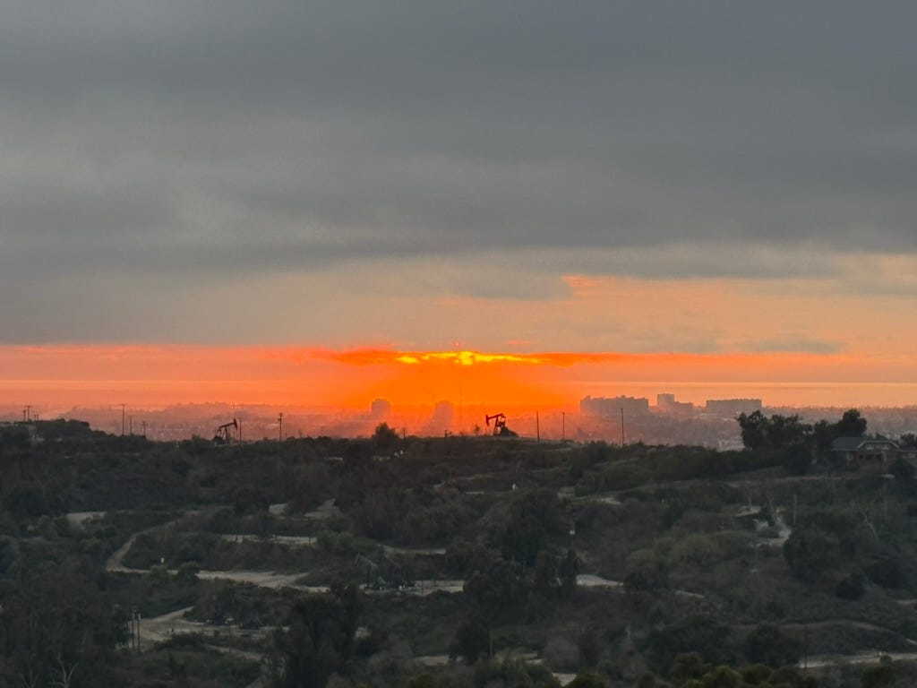 A sunset over a city

Description automatically generated