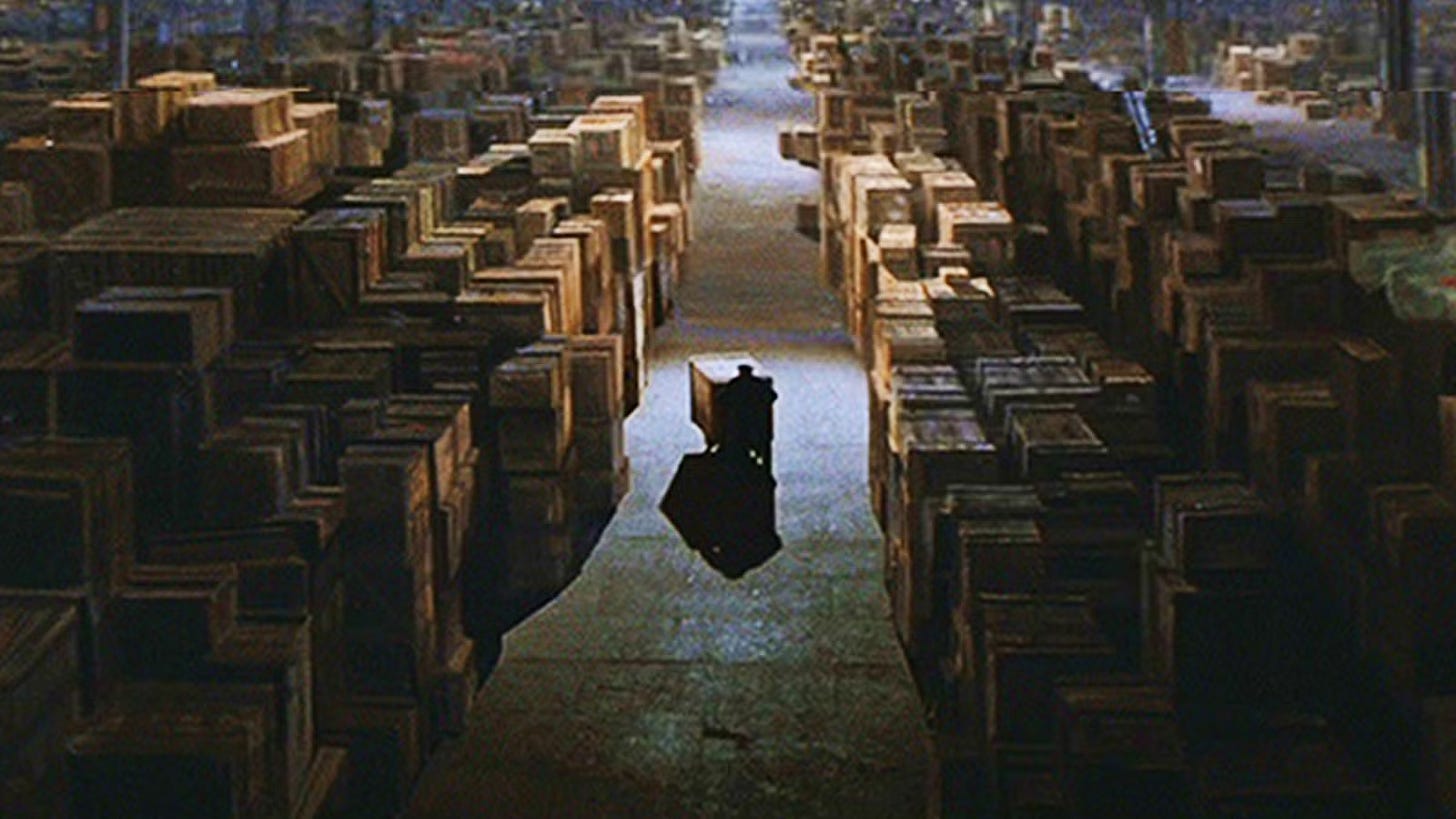 Scene from the end of the movie "Indiana Jones: Raiders of the Lost Ark." A worker is seen pushing a crate within an impossibly large collection of crates.