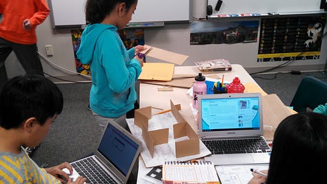 Students working on various projects throughout a classroom. 