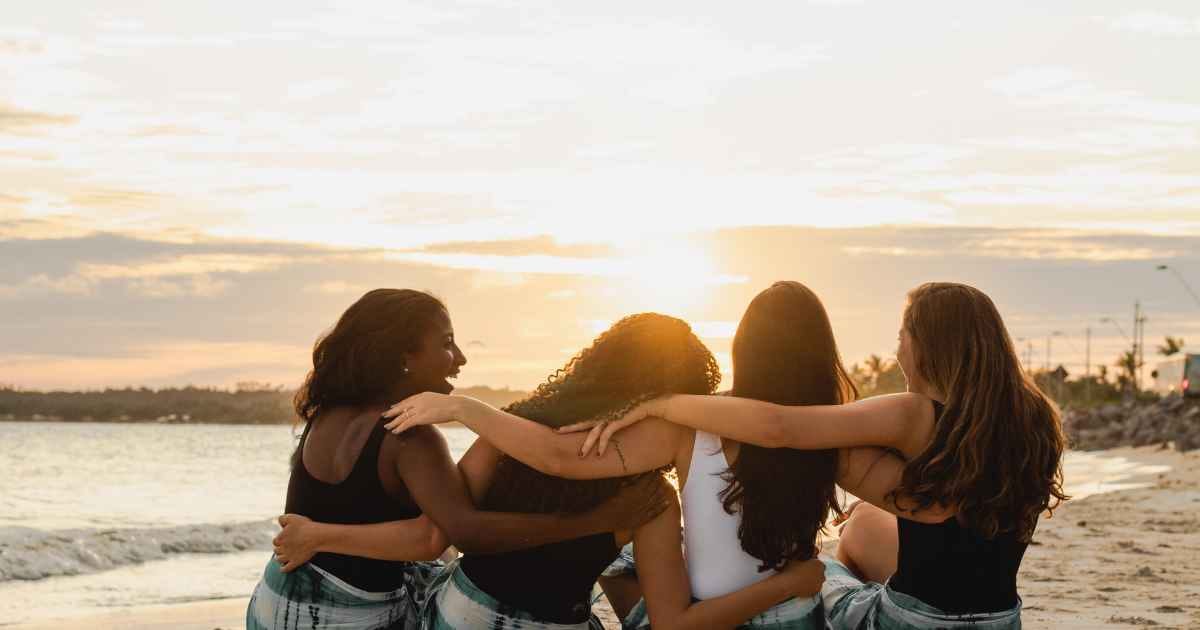 back view of a group of women sitting on the beach