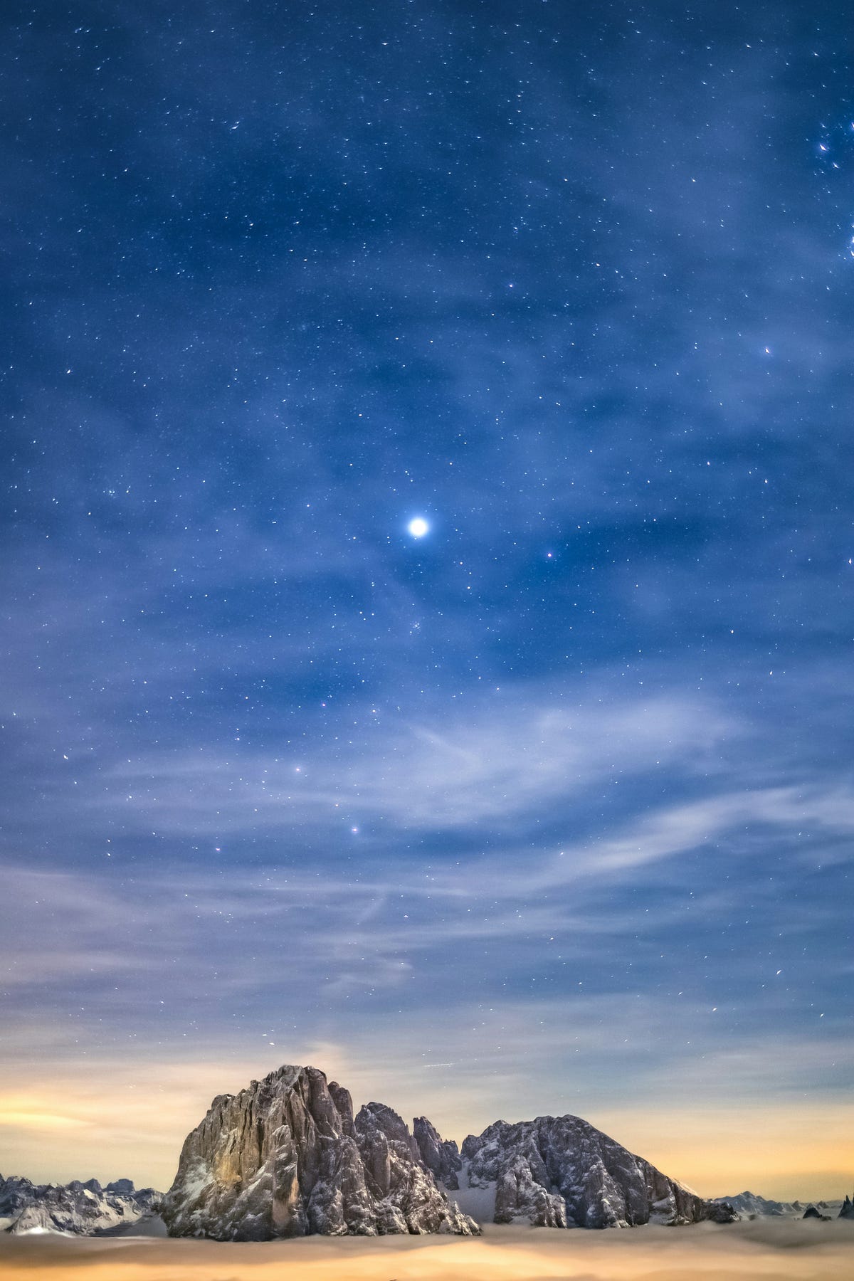a bright star in a nlue night sky over jagged rocks and sand a bright star in a nlue night sky over jagged rocks and sand